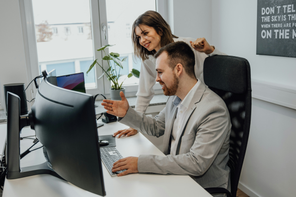 A man and a woman looking at a computer screen